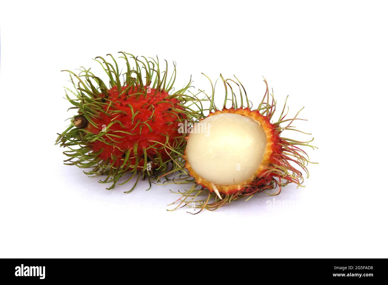 Sweet rambutans are peeled and placed separately on a white background, revealing the pulp of the fruit inside. Stock Photo
