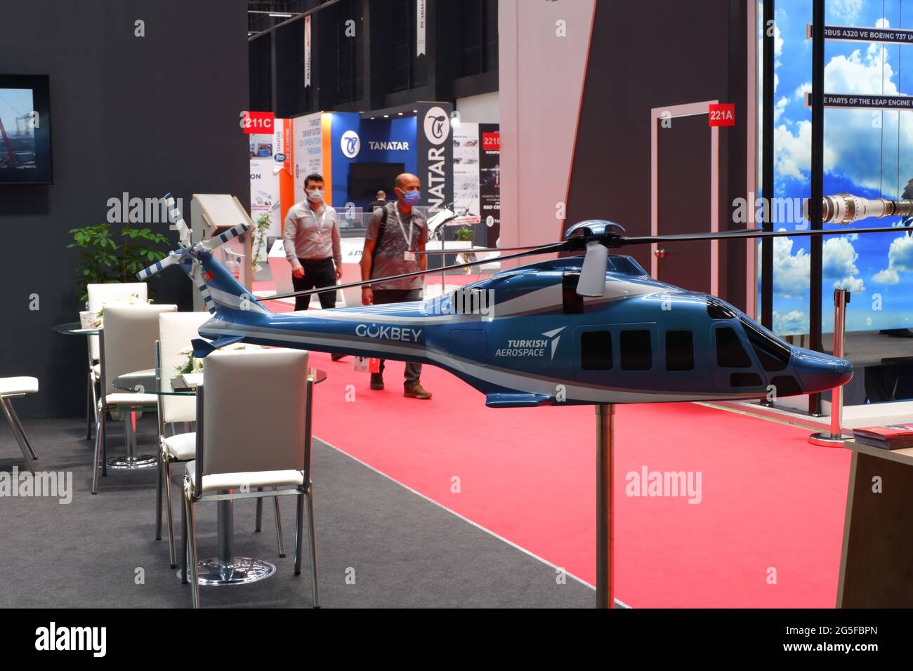 Model of a Turkish designed helicopter 'Gokbey' at an industrial fair during Covid Restriction with visitors wearing masks Stock Photo