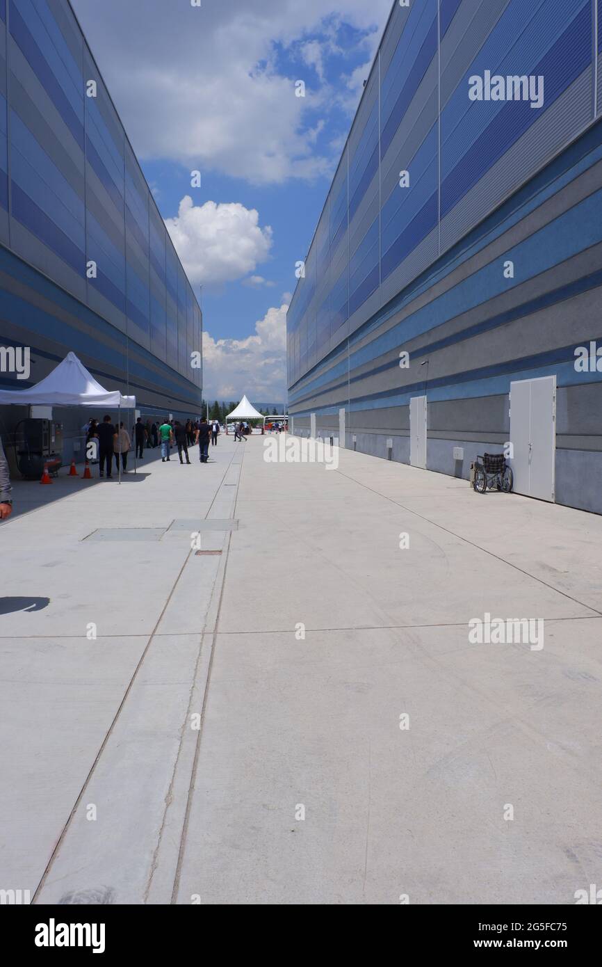 Long concrete Pavement between two large buildings in a sunny day outside Stock Photo