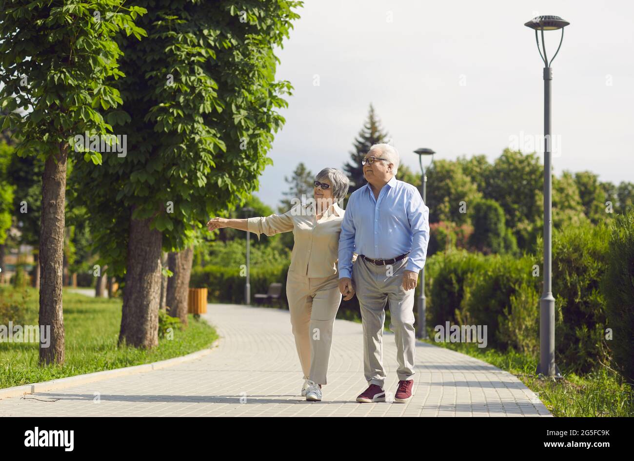 Healthy active senior old couple walking in park talking enjoy time together Stock Photo