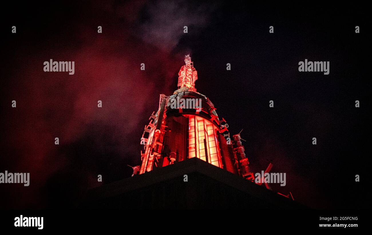 The spire of the ESB engulfed in red light and fog as seen from the viewing terrace on the 86th floor of the Empire State Building in New York City. The spire was originally built as a mooring for the airships of the time, but it also conveniently made the building taller than the contemporary Chrysler building. Stock Photo