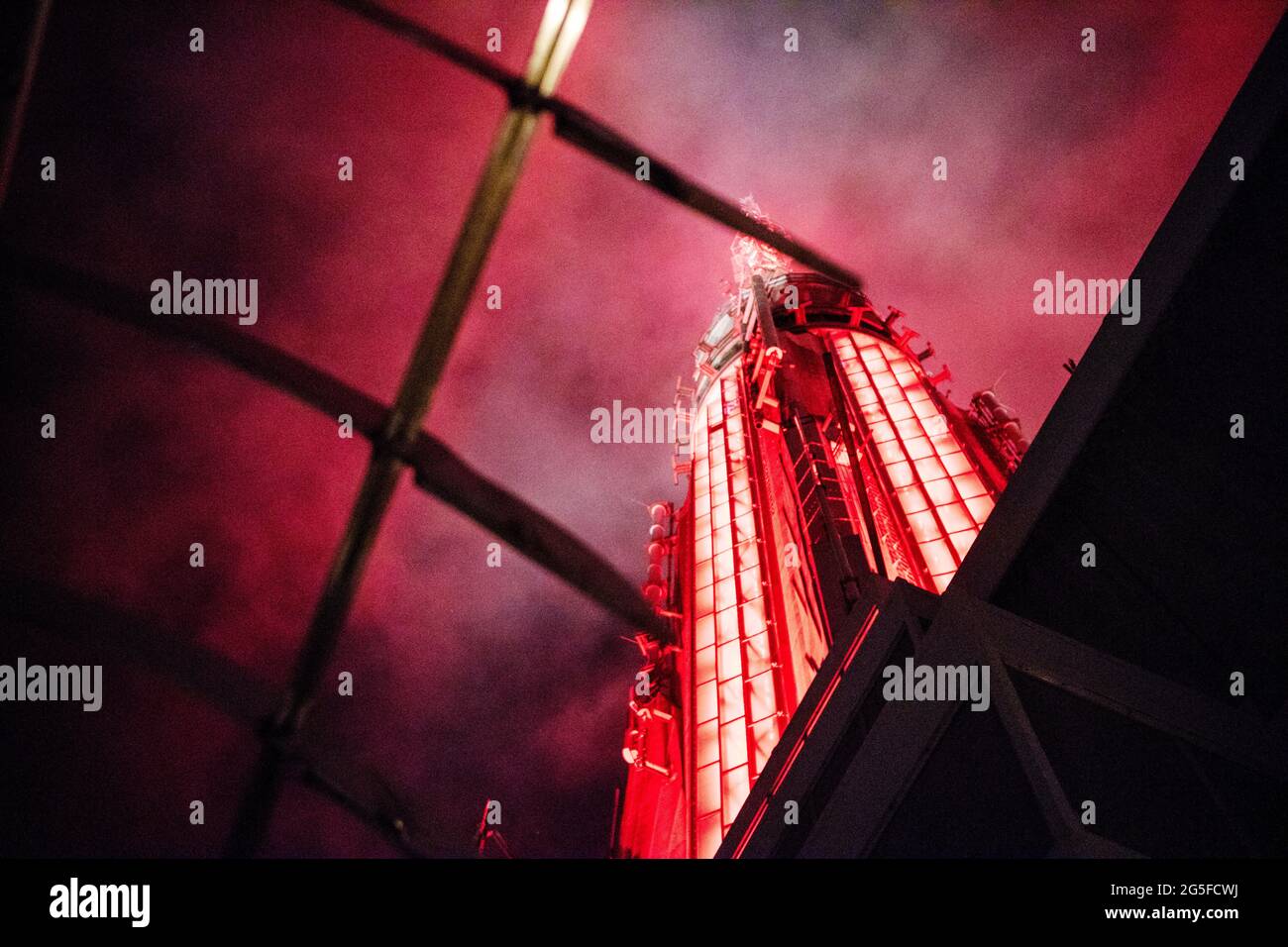 The spire of the ESB engulfed in red light and fog as seen from the viewing terrace on the 86th floor of the Empire State Building in New York City. The spire was originally built as a mooring for the airships of the time, but it also conveniently made the building taller than the contemporary Chrysler building. Stock Photo