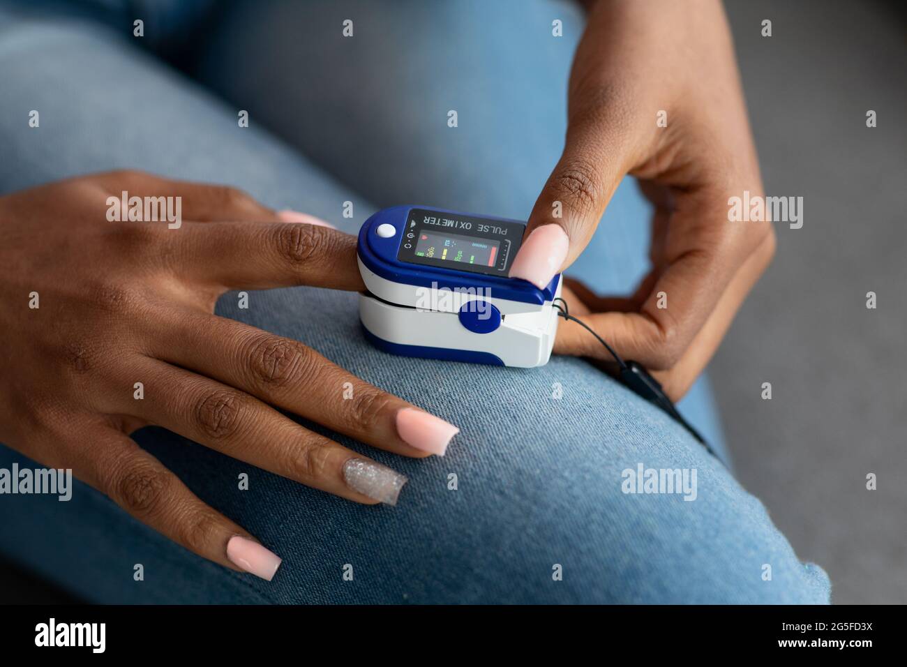 Unrecognizable African American Woman Using Oximeter At Home, Checking