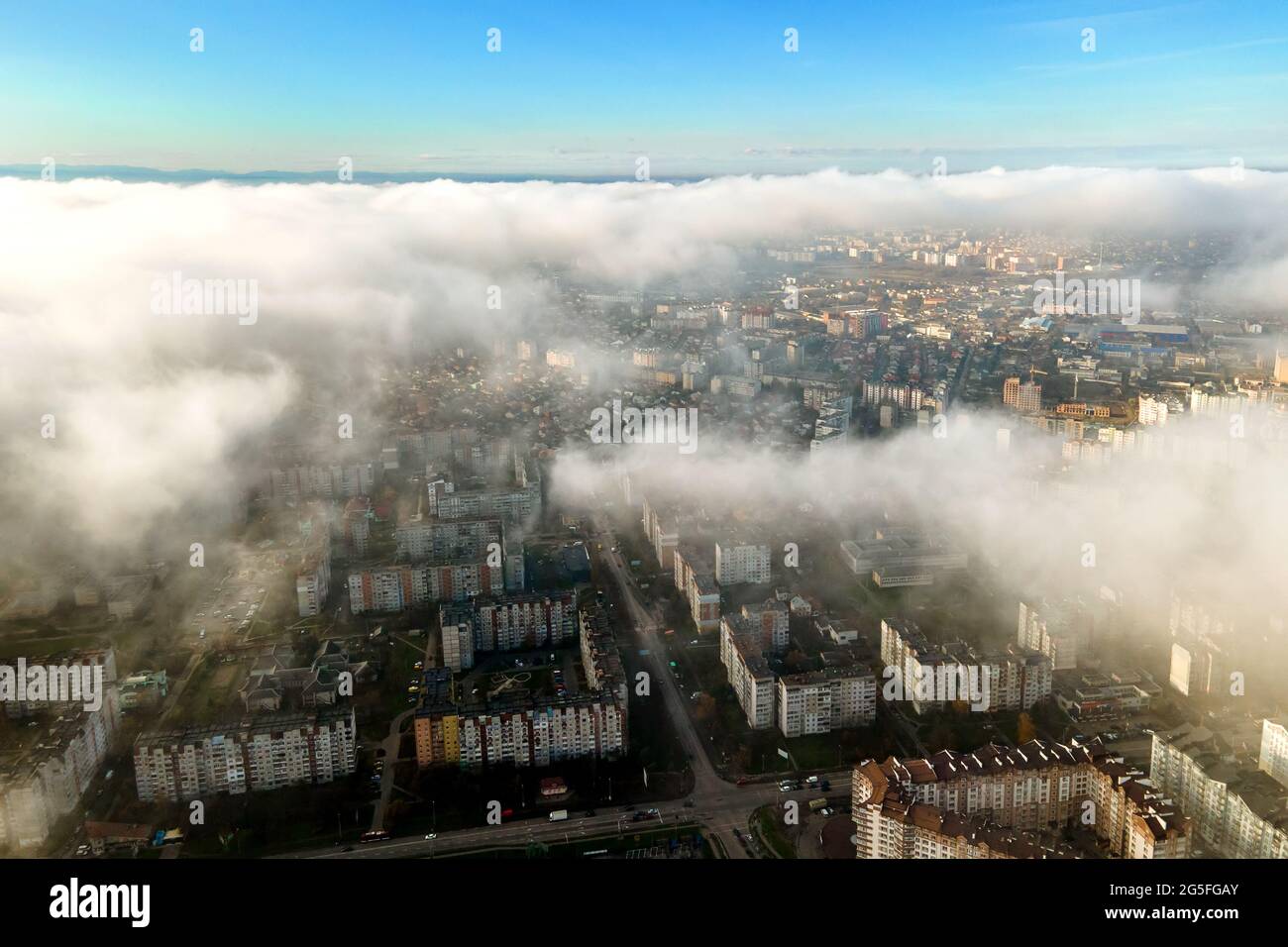 Top aerial view of fluffy white clouds over modern city with high rise ...