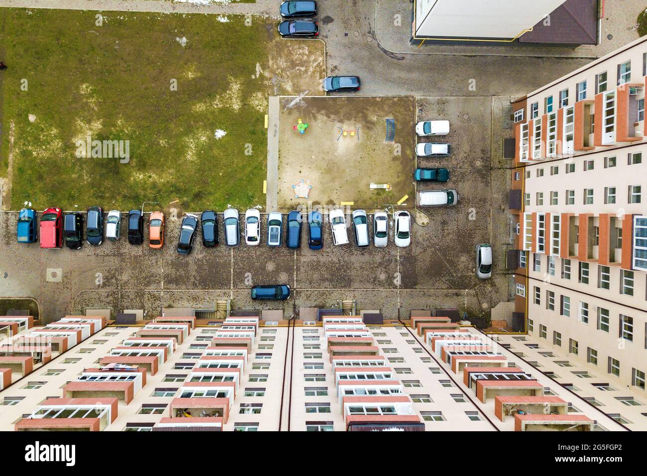 Aerial view of parked cars on parking lot between high apartment ...