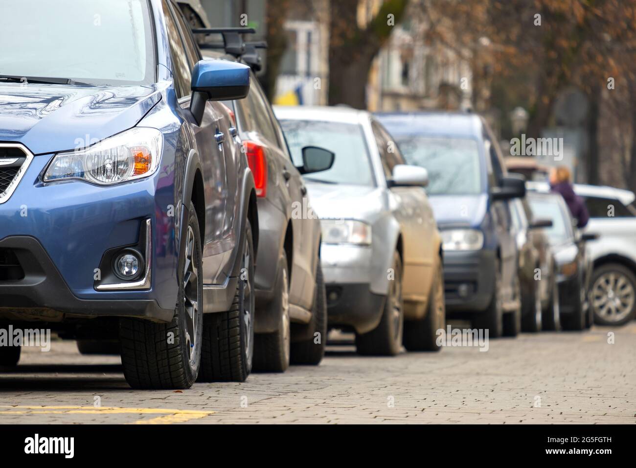 Cars parked in a row on a city street side Stock Photo - Alamy