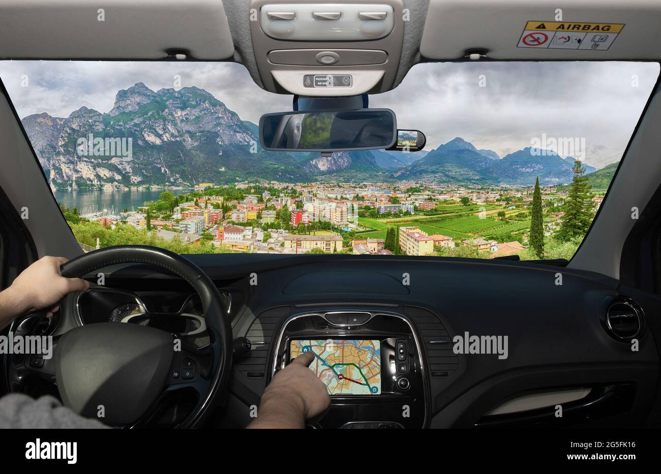 Driving a car while using the touch screen of a GPS navigation system towards Riva del Garda, Northern Lake Garda, Trento, Italy Stock Photo