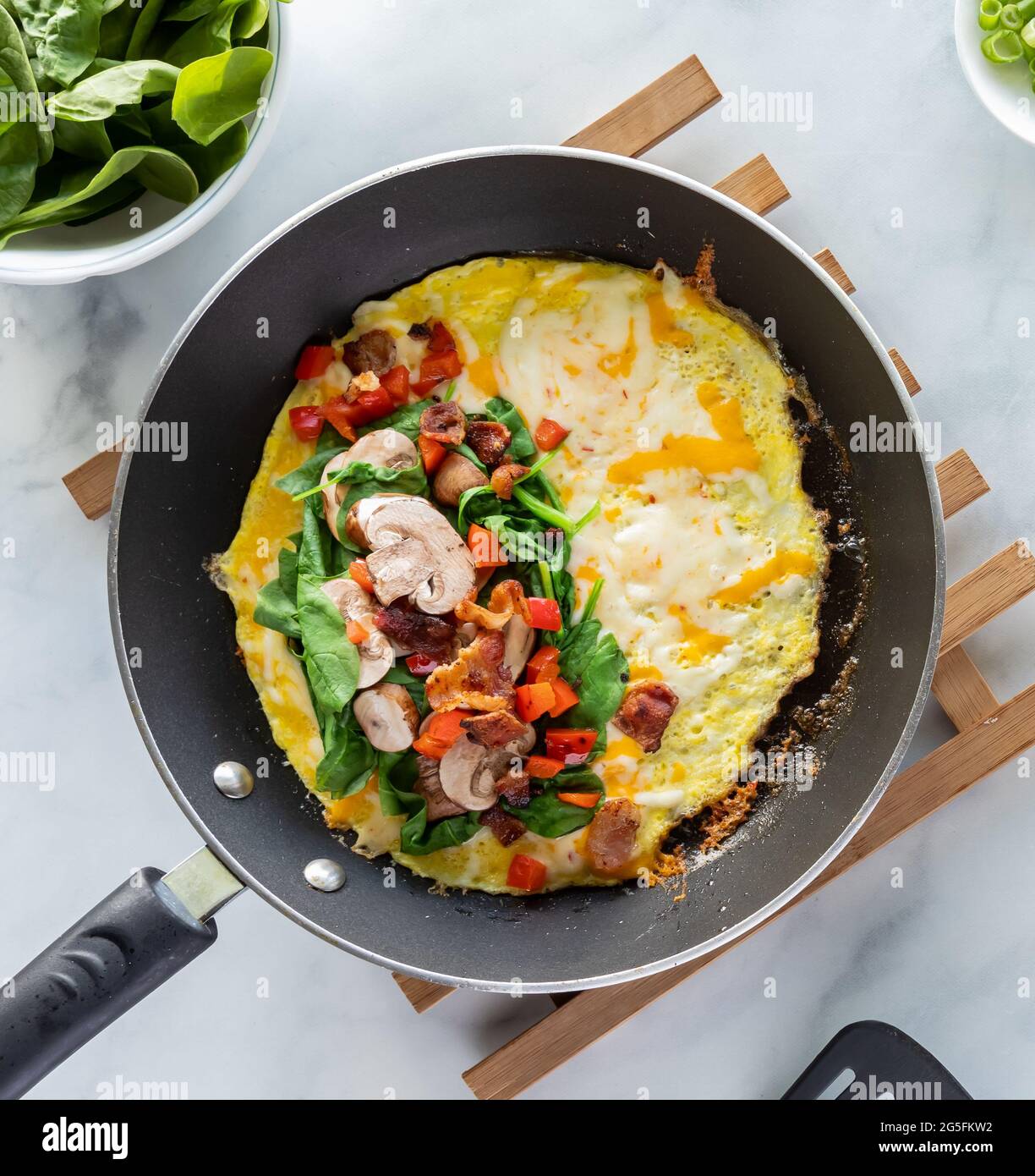 Top down look into a fry pan with the ingredients of the inside of an omelette right before folding. Stock Photo