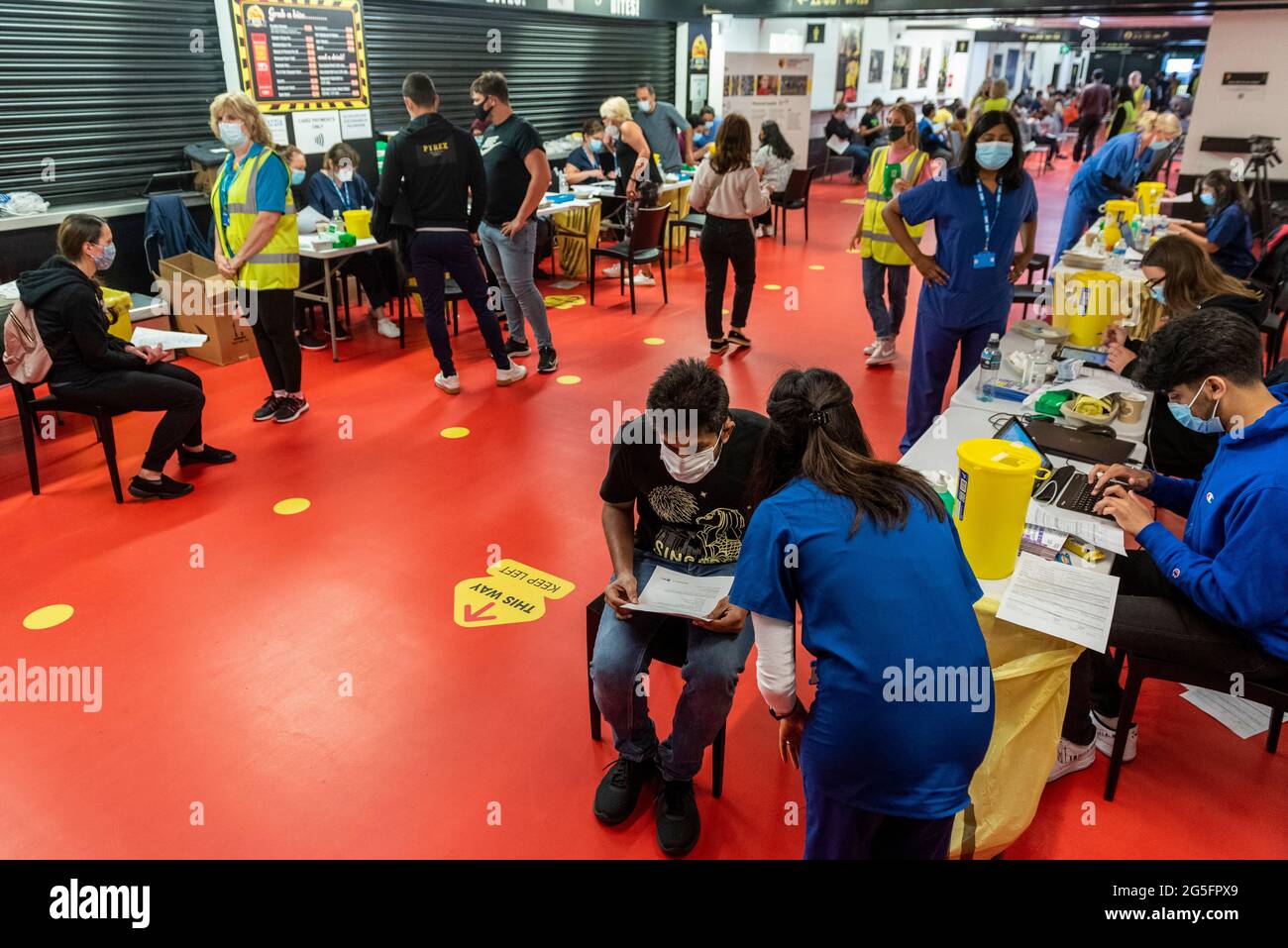 Watford, UK.  27 June 2021. General view of the pop-up mass vaccination clinic at Watford FC’s Vicarage Road Stadium as part of the “Grab a jab” campaign. The NHS is also promoting a number of walk-in clinics this weekend across the capital to try to increase the number of over 18s receiving a jab as cases of the Delta variant are reported to be on the rise.  Credit: Stephen Chung / Alamy Live News Stock Photo