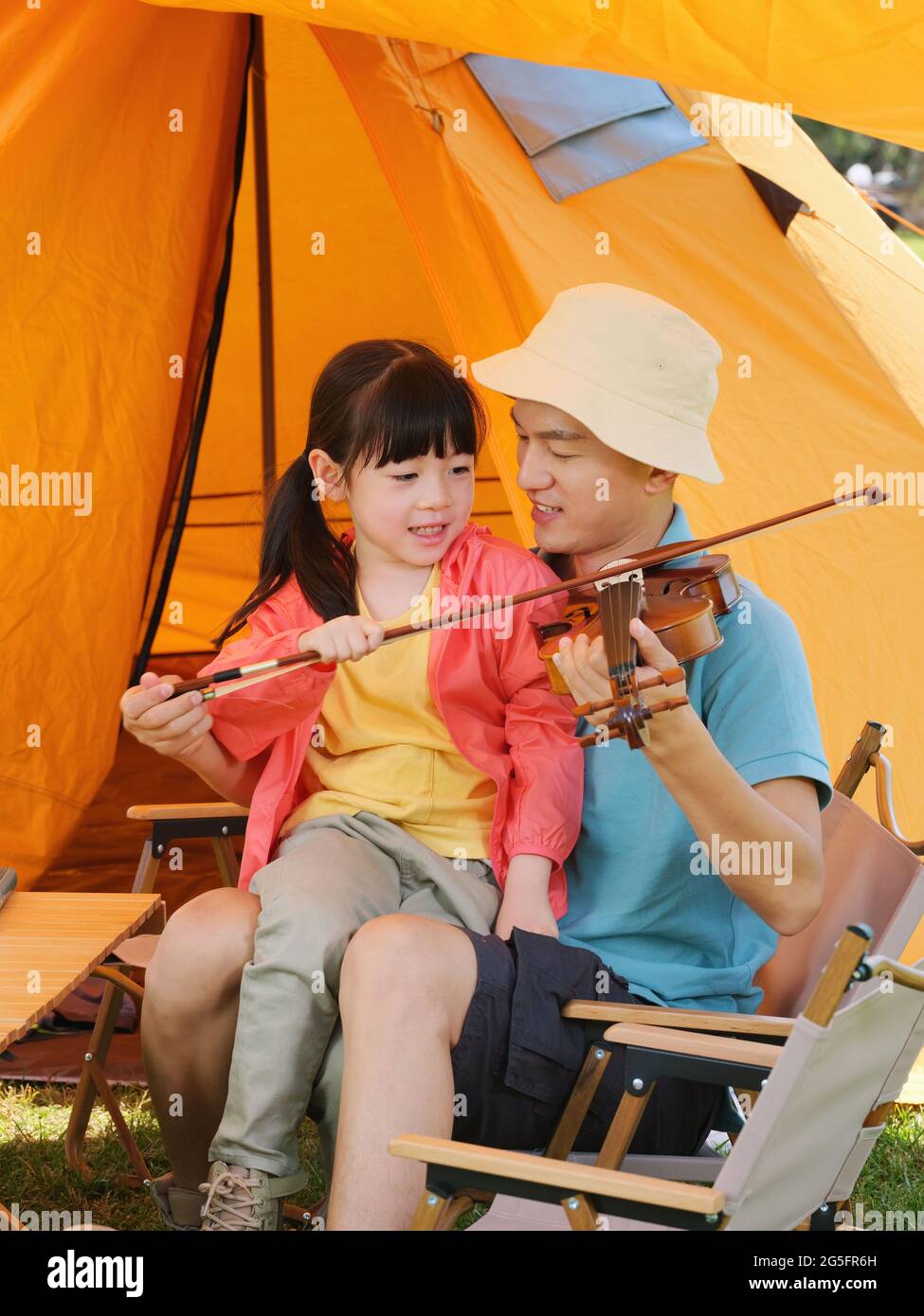 The young father taught his daughter to play the violin high quality