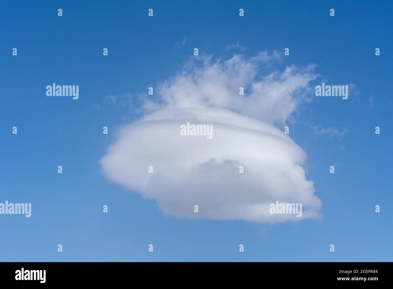Lenticular cloud with more clouds coming out of the top creating a pot shape with steam. Stock Photo