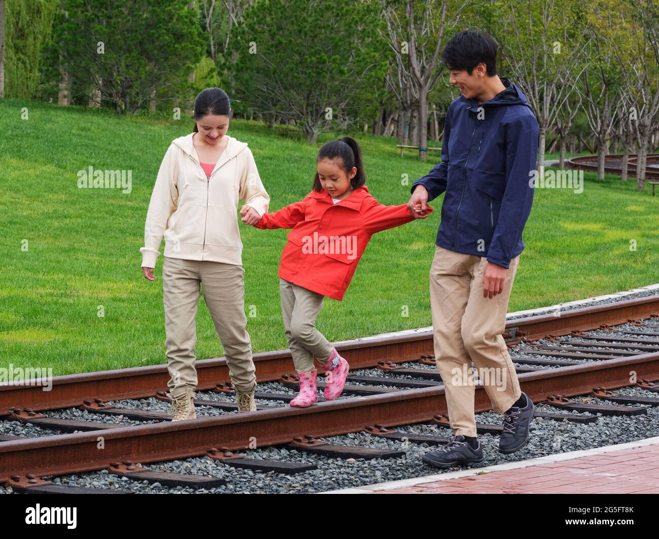 A happy family of three walking outdoors high quality photo Stock Photo