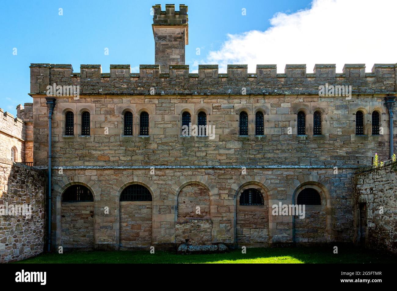 The shaded rear of the male debtors and female criminals block revealing battlements, partially blocked round headed window,s and the exercise yard Stock Photo