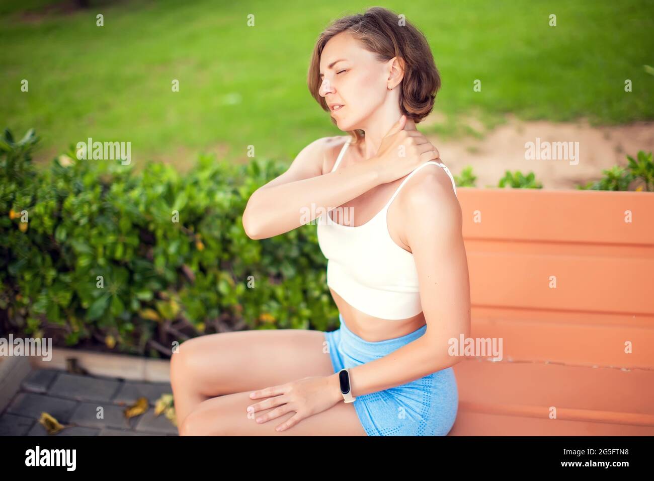 Neck pain. Woman feeling neck or shoulder ache outdoor. Healthcare and lifestyle concept Stock Photo