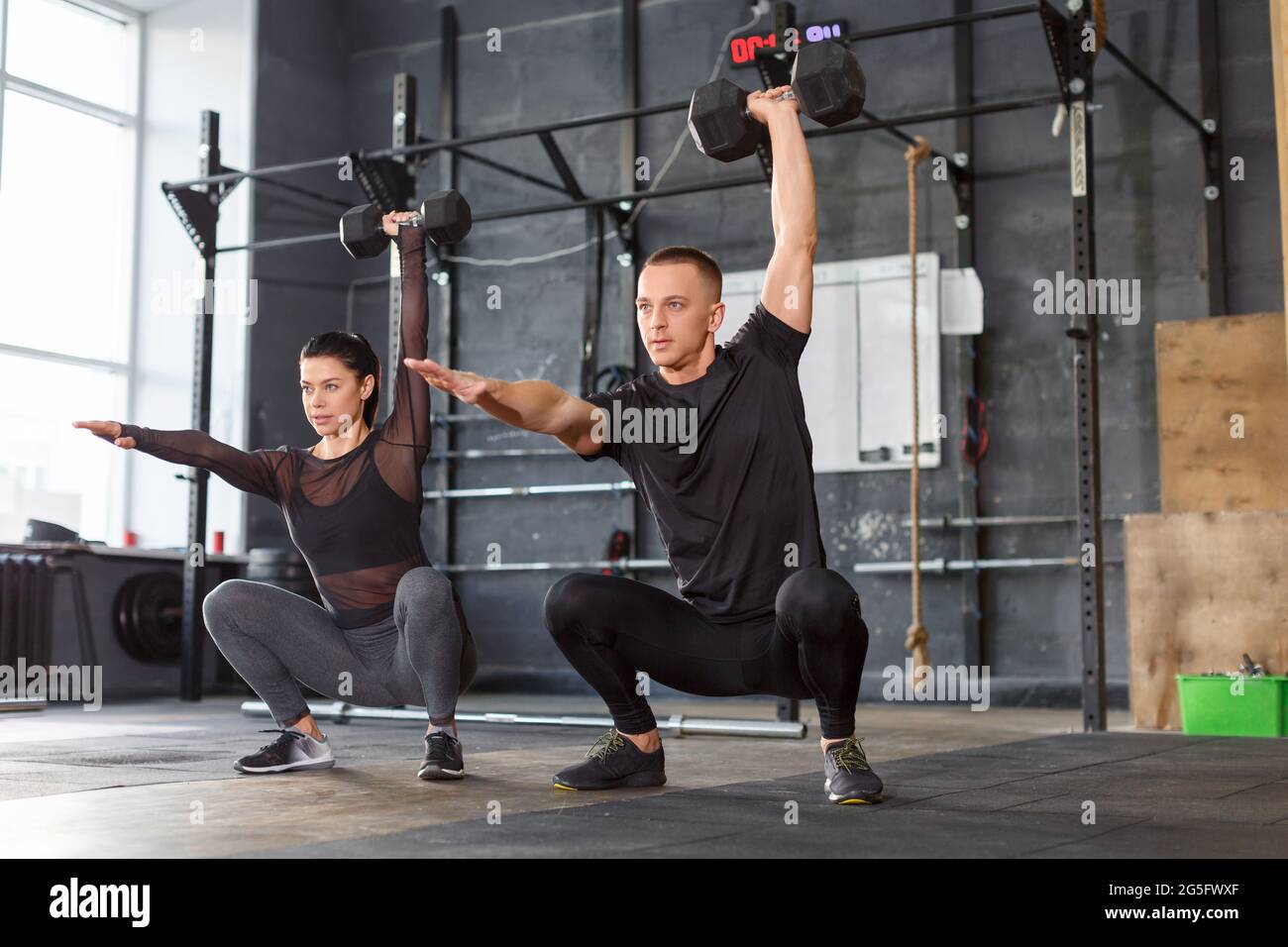 Healthy lifestyle concept - photo of an attractive sports people are  lifting dumbbells together at crossfit gym Stock Photo - Alamy