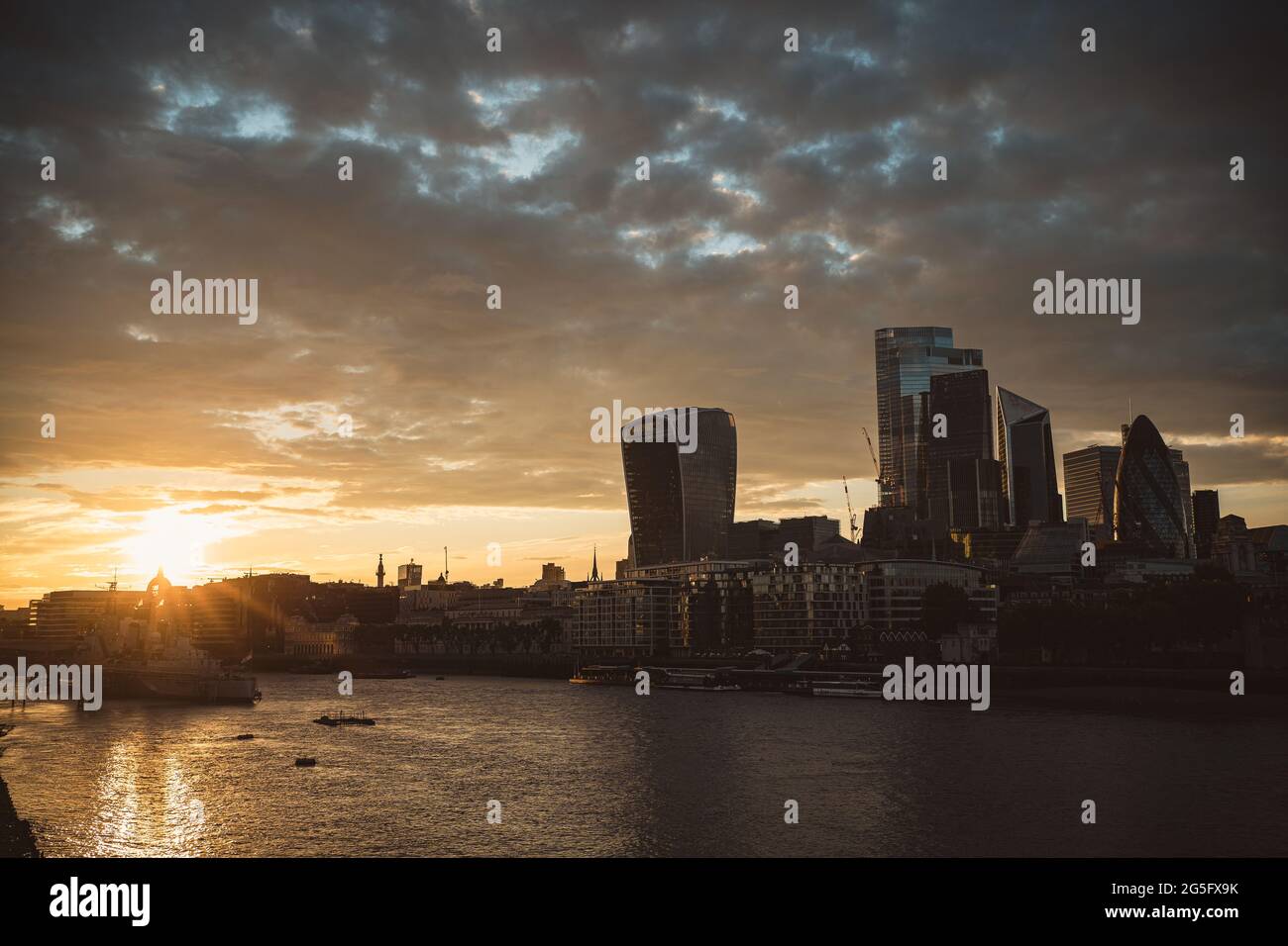 Thames River Embankment, London | UK - 2021.06.26: The view of the CIty Business District from the thames river on beautiful sunset evening Stock Photo