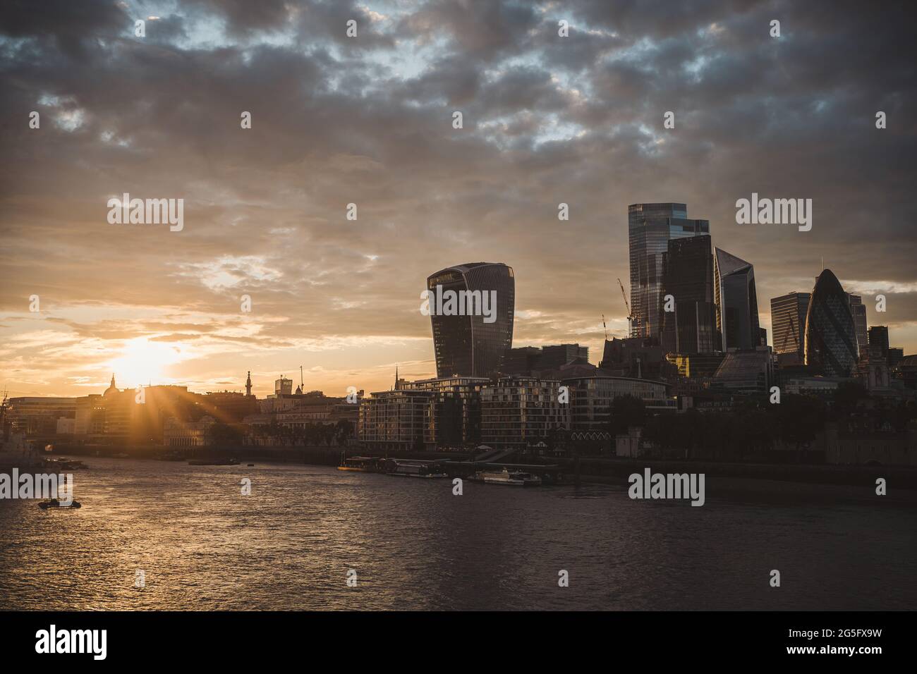 Thames River Embankment, London | UK - 2021.06.26: The view of the CIty Business District from the thames river on beautiful sunset evening Stock Photo