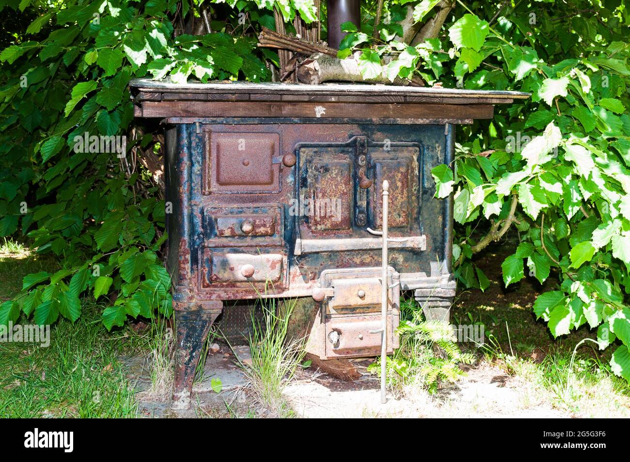 Old kitchen stove that was fired with wood. It is decorative and already rusting slightly in the garden Stock Photo