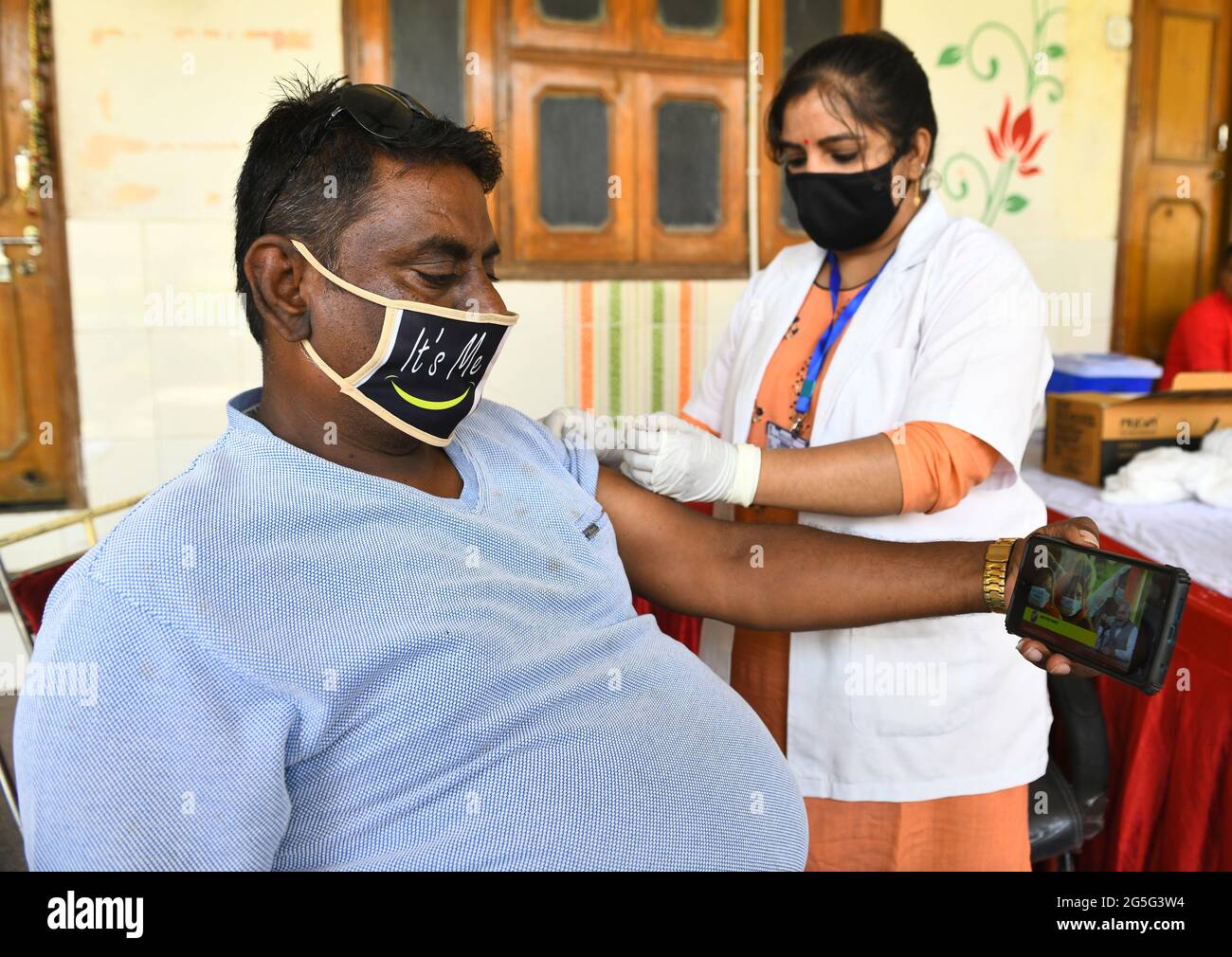 Beawar, India. 27th June, 2021. A beneficiary listen to Indian Prime Minister Narendra Modi's 'Mann ki Baat' as he receives a dose of COVID-19 vaccine during a special one-day vaccination drive at a vaccination center in Beawar. PM Modi speaks about Indian participation in Olympics, vaccine hesitancy, rainwater harvesting and more. (Photo by Sumit Saraswat/Pacific Press) Credit: Pacific Press Media Production Corp./Alamy Live News Stock Photo