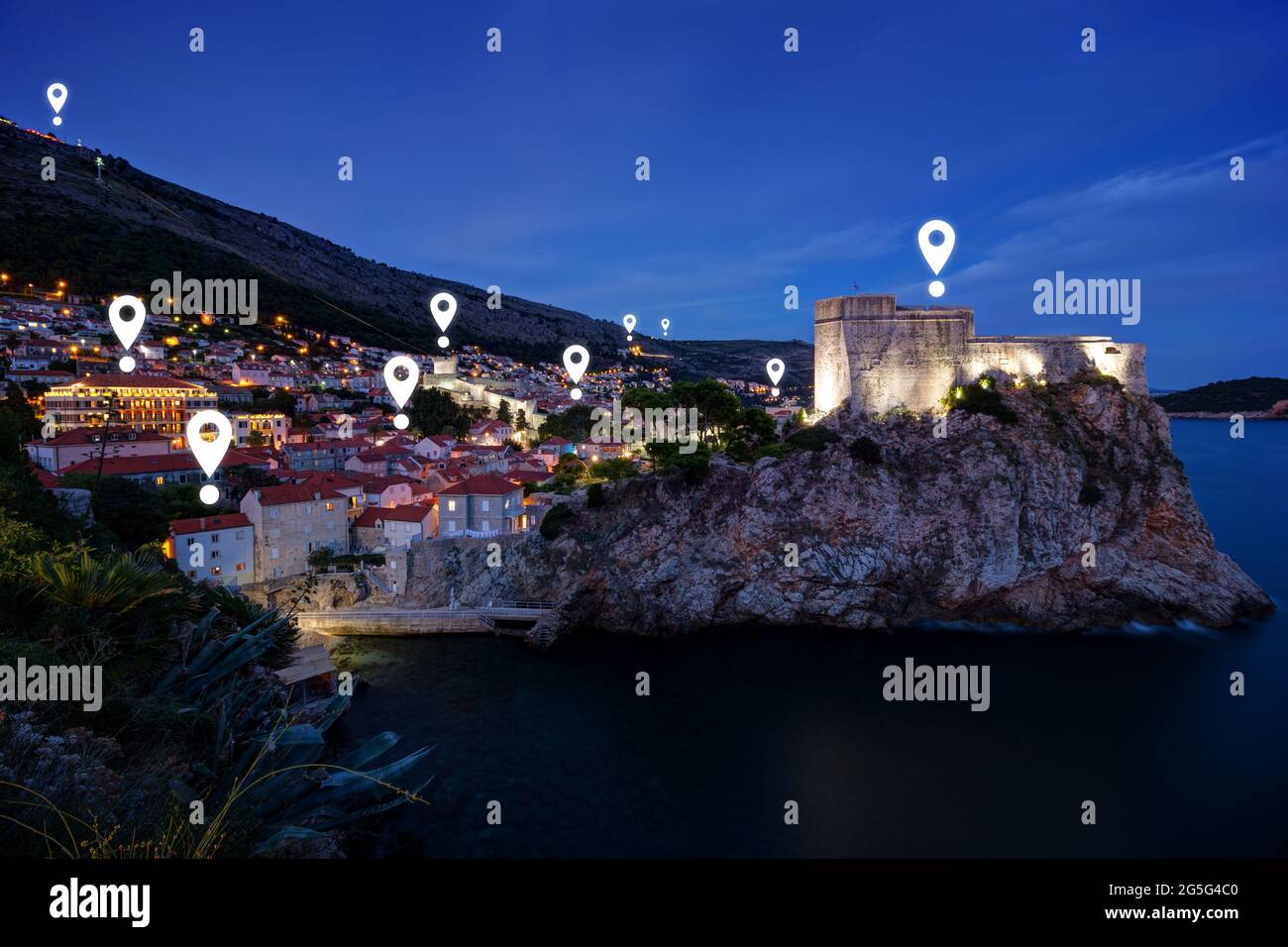 Map pin icons on Dubrovnik's cityscape at dusk. Old Town of Dubrovnik and Fort Lovrijenac in Croatia at night. Stock Photo