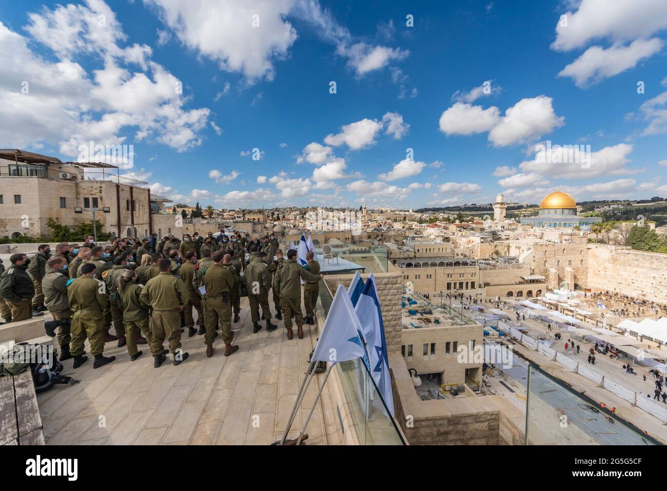 A group of Israeli soldiers on top of the 'Or Hatorah' Yeshiva (Jewish religious college), overlooking the western wall and the temple mount with the famous golden dome. Stock Photo