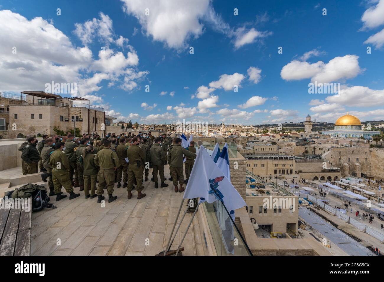 A group of Israeli soldiers on top of the 'Or Hatorah' Yeshiva (Jewish religious college), overlooking the western wall and the temple mount with the famous golden dome. Stock Photo