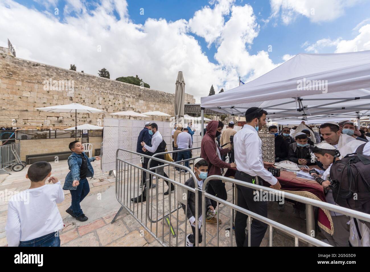 Jerusalem, Israel. A bar Mitzvah ceremony at the Western Wall, one of the holliest places for Judaism, during the COVID pandemic. The area was equipped with barriers and dividers to seperate people praying and keep a measure of social distancing. Stock Photo