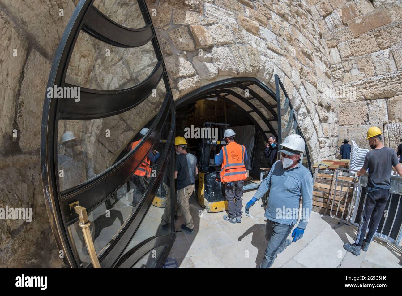Jerusalem, Israel. construction workers work at the tunnels of the Western Wall, one of the holliest places for Judaism, also known as the 'Wailling wall', with facemasks and security equipment to keep them safe during the COVID pandemic. Stock Photo