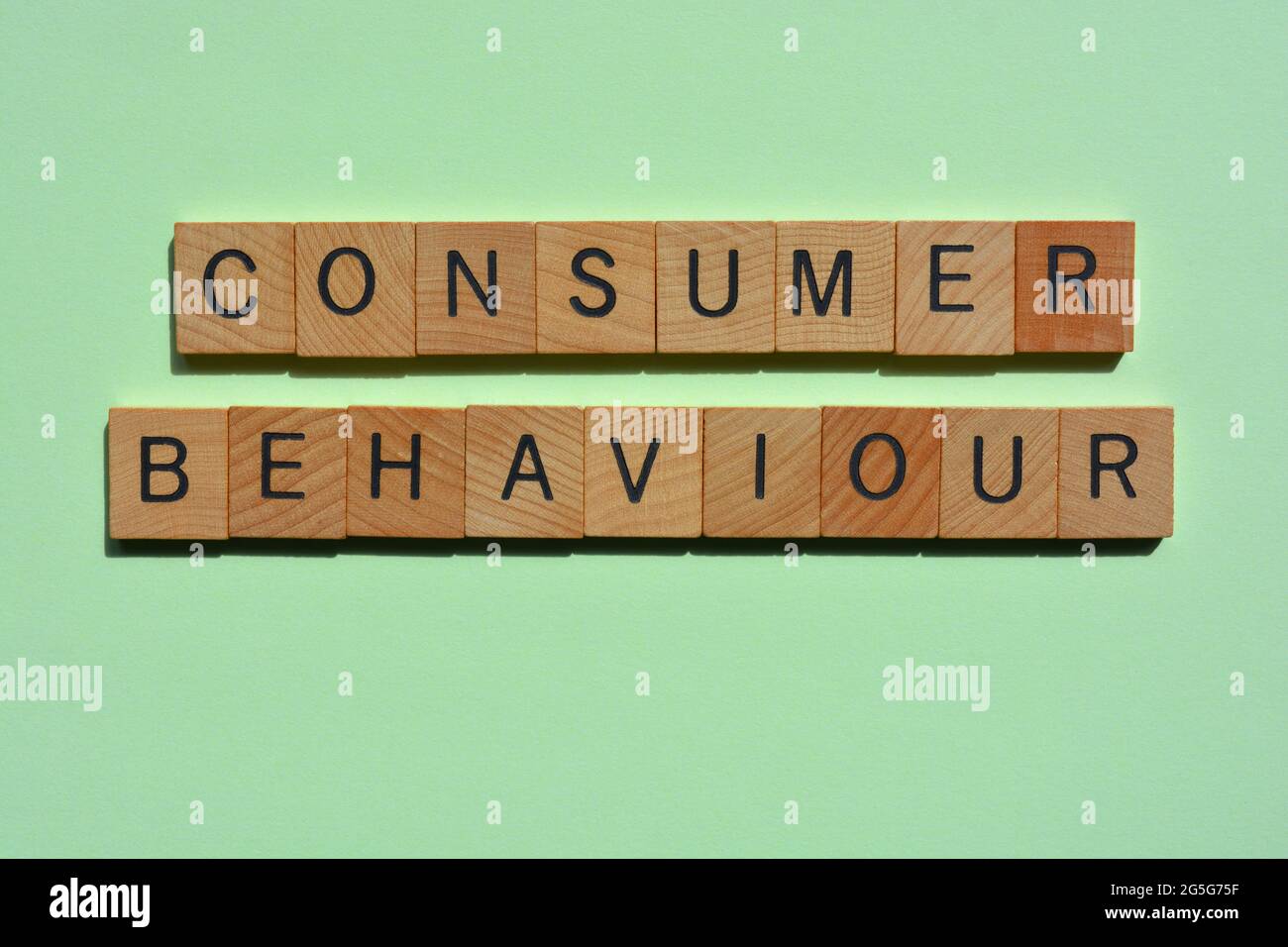 Consumer Behaviour, words in wooden alphabet letters isolated on green background Stock Photo