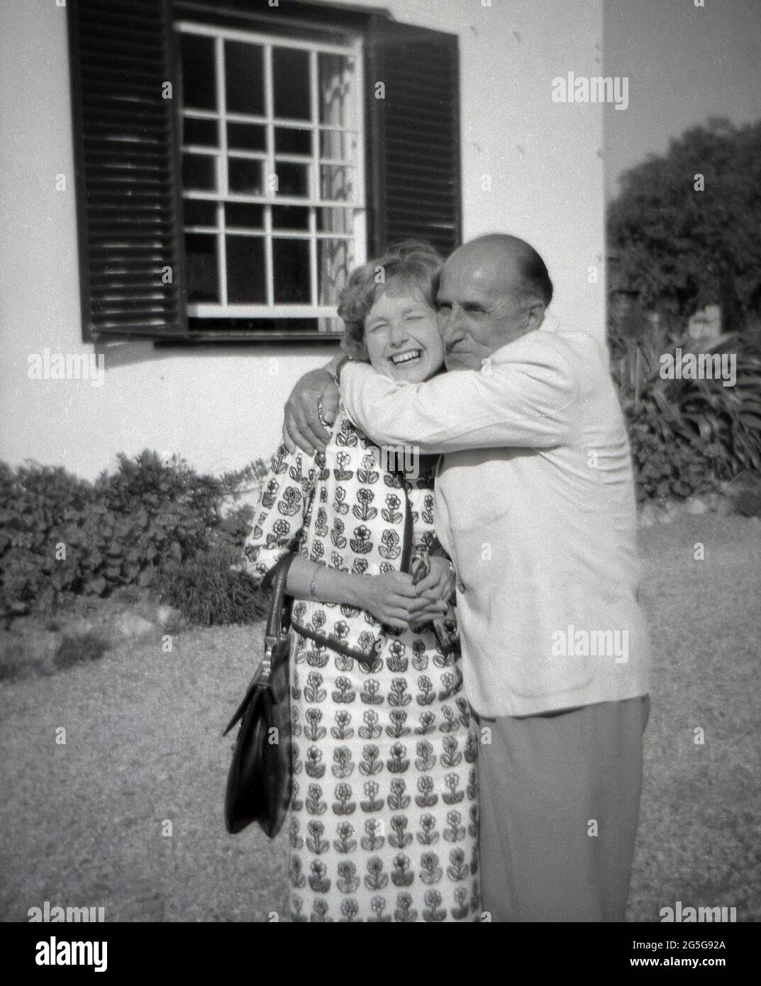 1960s, historical, an elegant young English lady getting a real Italian 'Benvenuto', a warm welcome and a big hug, from an older Italian male, Italy. The Italian people are known for their friendly nature and hospitality. Stock Photo