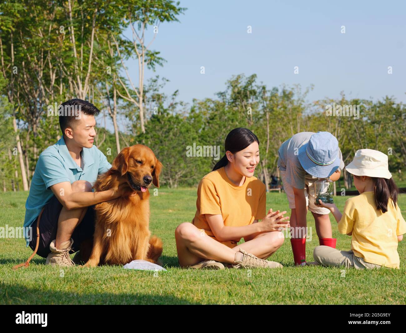 Happy family of four and pet dog playing in the park high quality photo Stock Photo