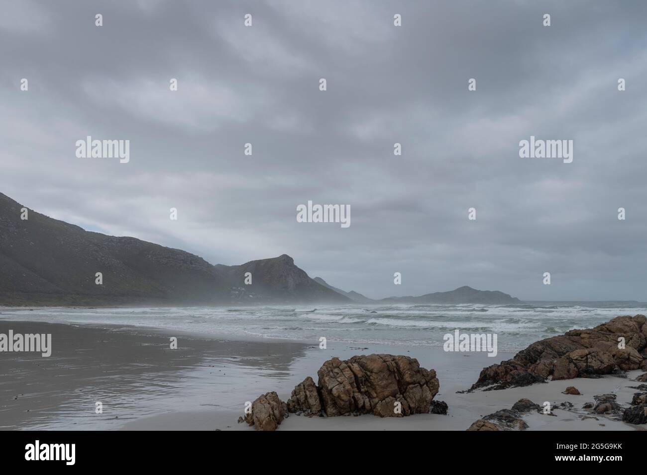 View of Misty Cliffs on Cape Peninsula Atlantic coast from Witsands beach, Cape Town, South Africa. On overcast, cold, wet day. Winter. Stock Photo