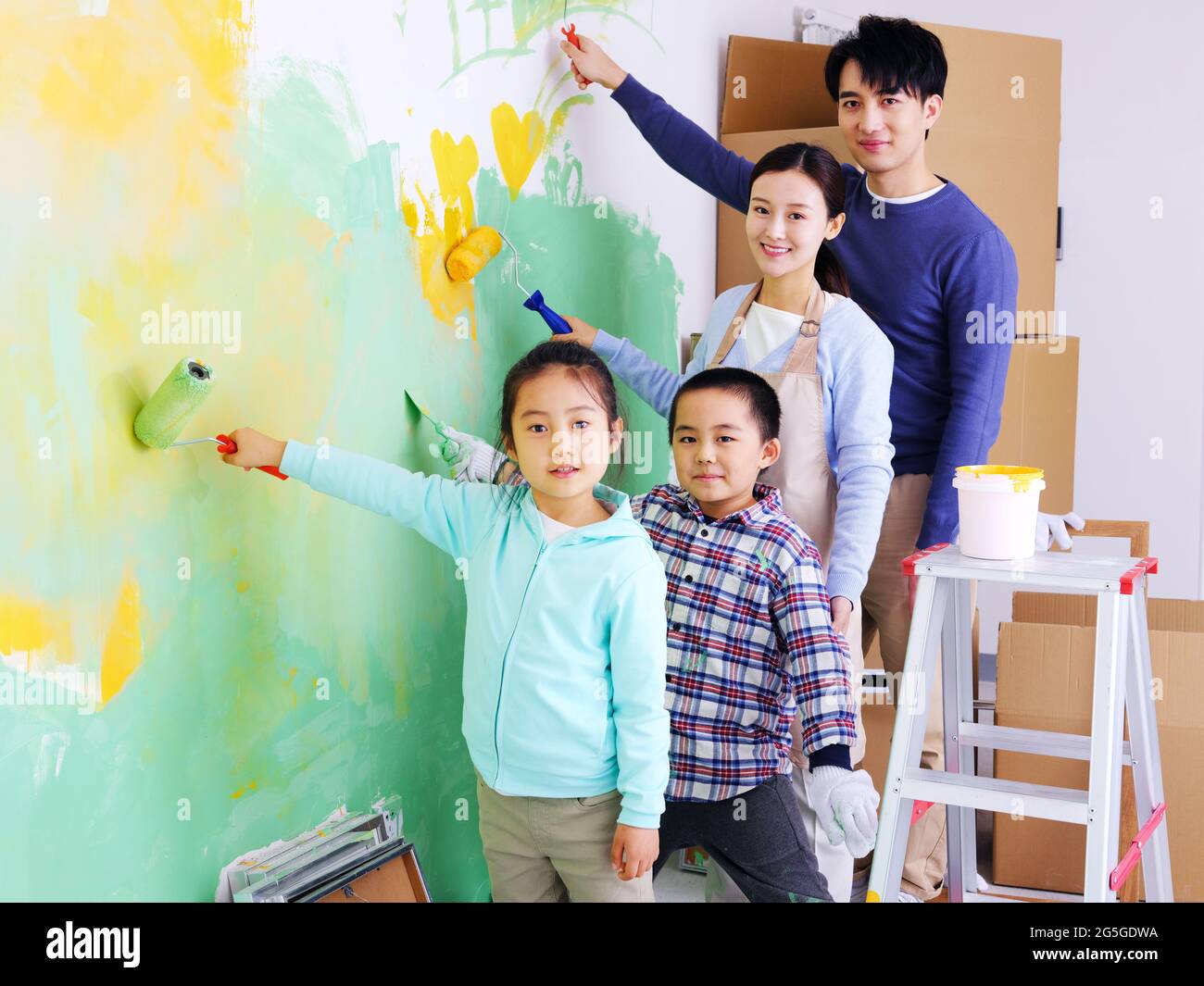 A happy family of four painting walls high quality photo Stock Photo