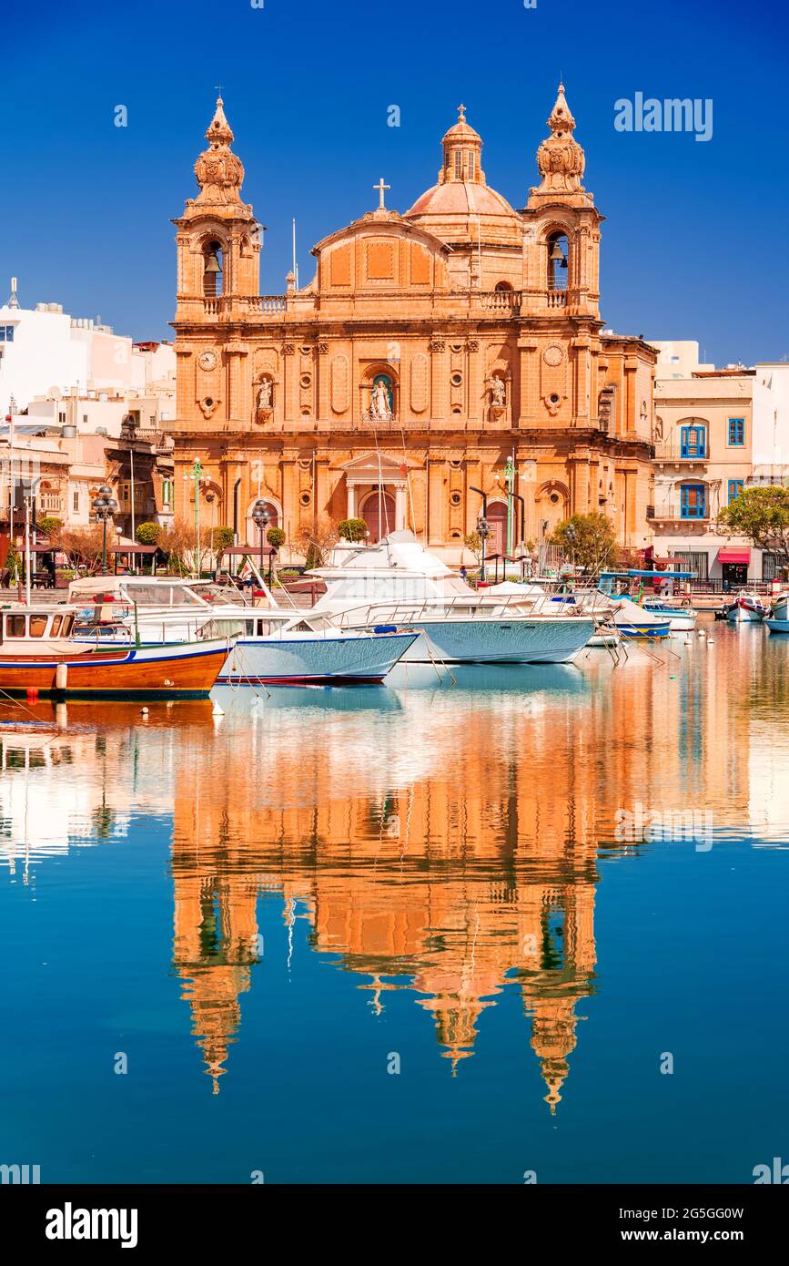 Valletta, Malta. Msida Marina boat and St Joseph Church reflection into water. Stock Photo