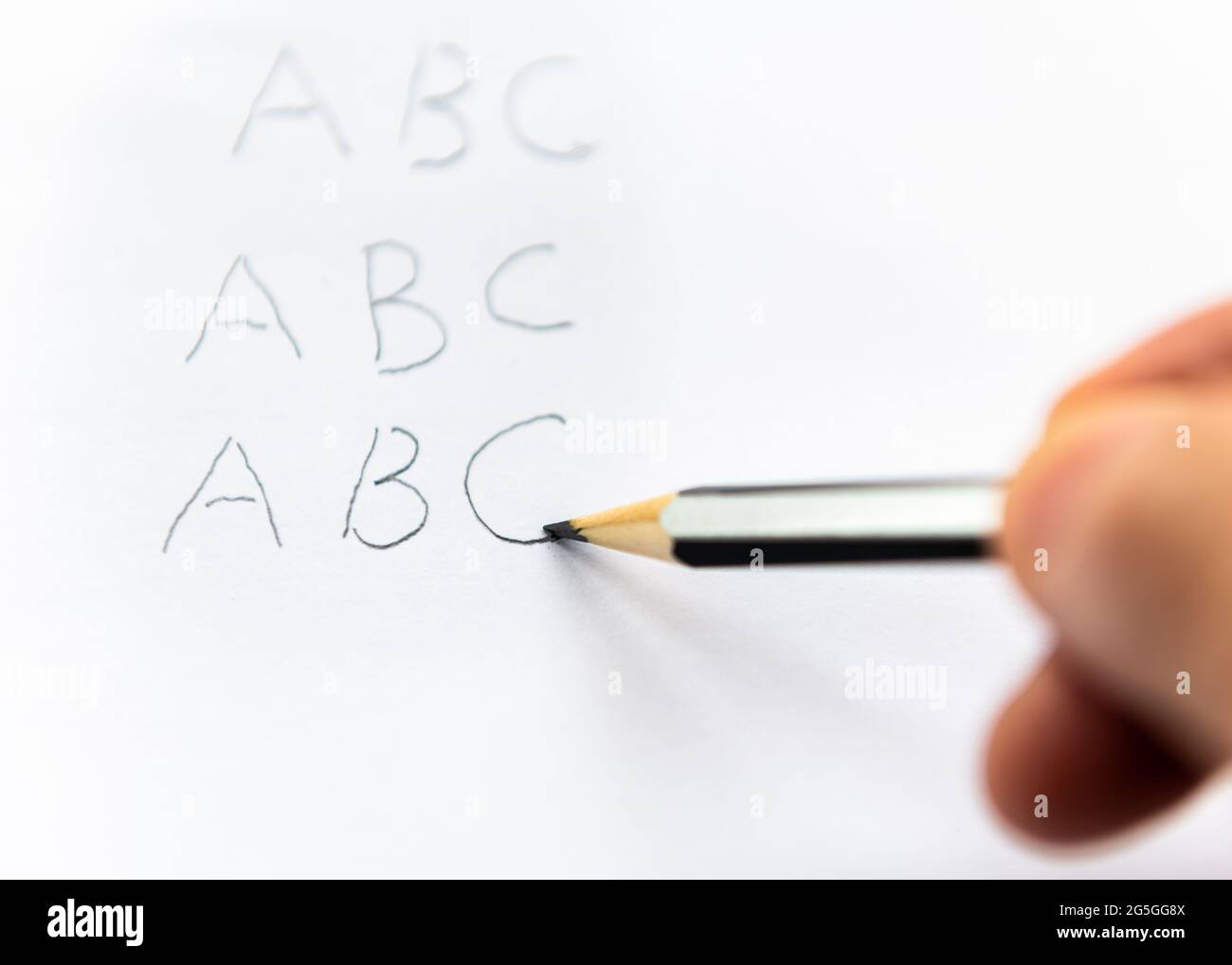 A person writing the alphabet with a pencil. Earning learning concept