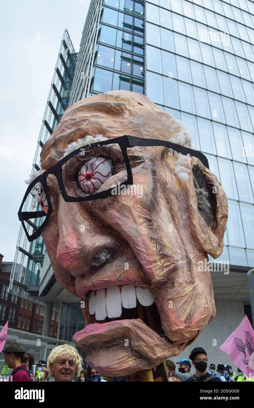 London, United Kingdom. 27th June 2021. A protester holds a paper-mache head of Rupert Murdoch outside News UK during the Free The Press demonstration. Extinction Rebellion demonstrators marched from Parliament Square to News UK headquarters, owned by Rupert Murdoch, in London Bridge, in protest of misinformation, corruption, and the inaccurate and insufficient coverage of the climate crisis by Murdoch's newspapers. (Credit: Vuk Valcic / Alamy Live News) Stock Photo