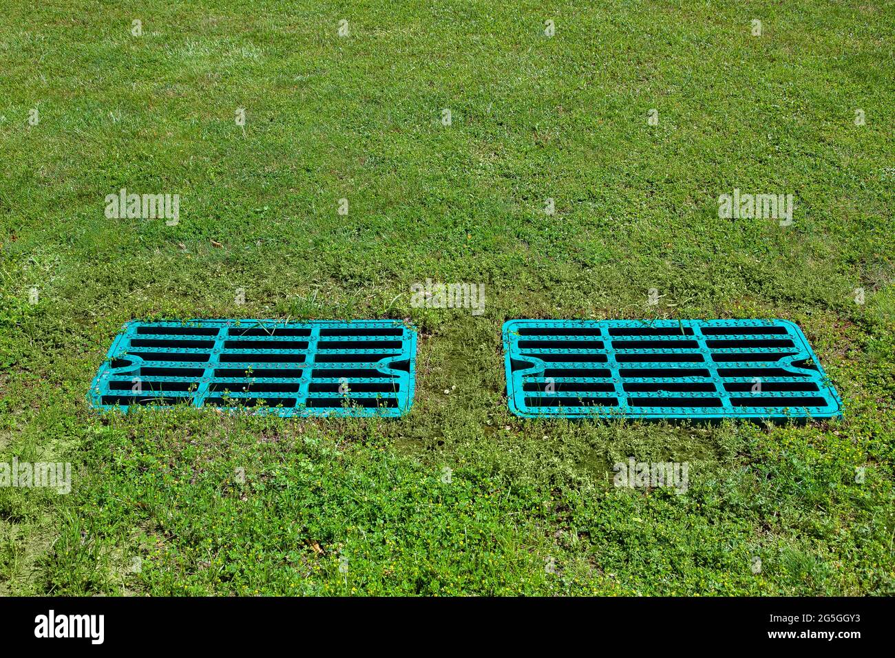 manhole drainage grates on the lawn with green grass septic tank cover, sump cesspool drainage system environment design with copy space, nobody. Stock Photo