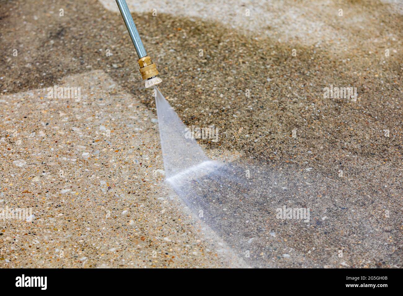 Pressure washing and cleaning dirty concrete driveway. Home cleaning