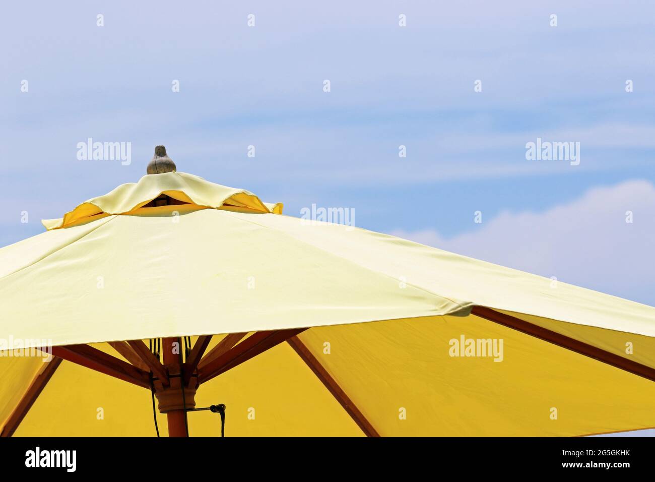 A bright yellow market umbrella popular for al fresco dining Stock