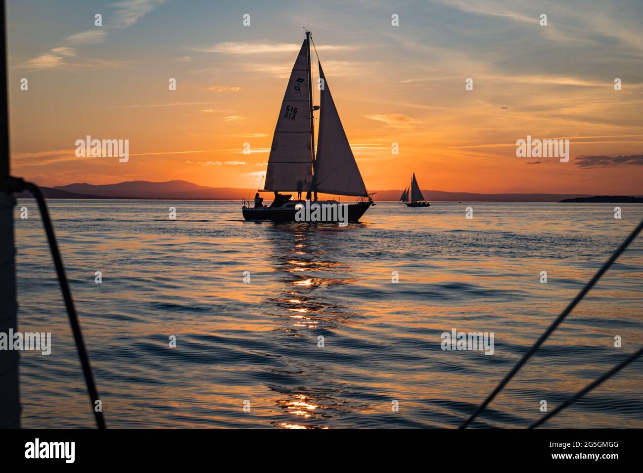 setting sun on Lake Champlain enjoyed by sail boats Stock Photo