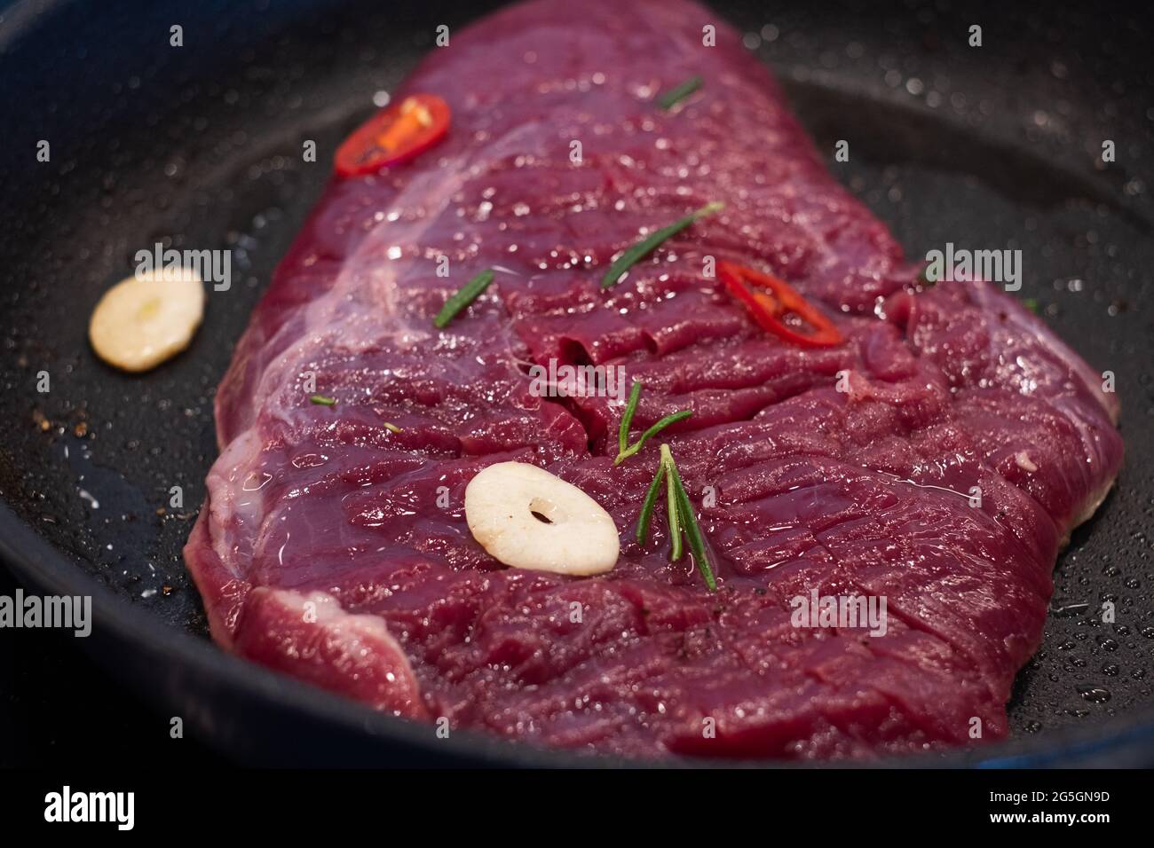 Raw red meet frying on oily pan. Cooking meat. Stock Photo