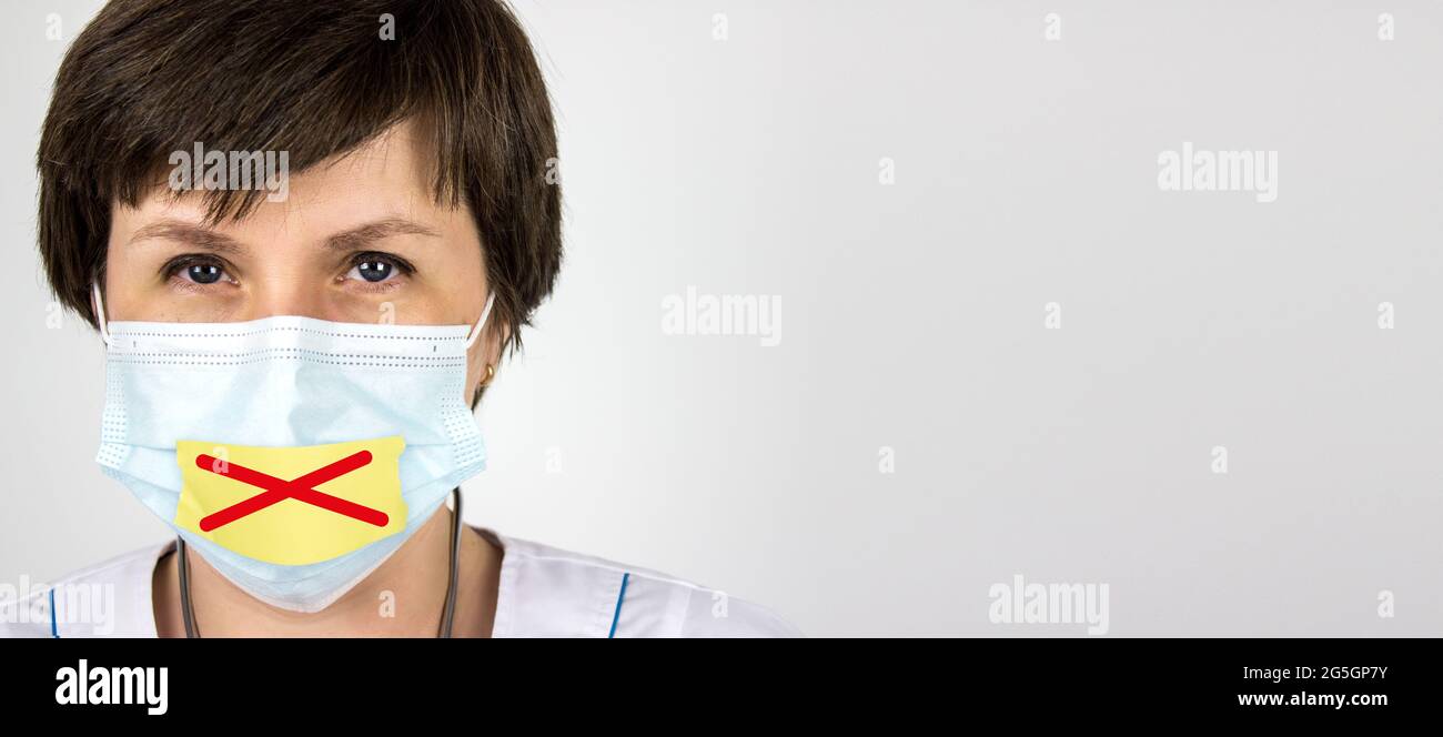 Medical secrecy concept. Doctor with tape sealed over his mouth. Tape mouth and hold back the truth about real number of cases sick on coronavirus cov Stock Photo