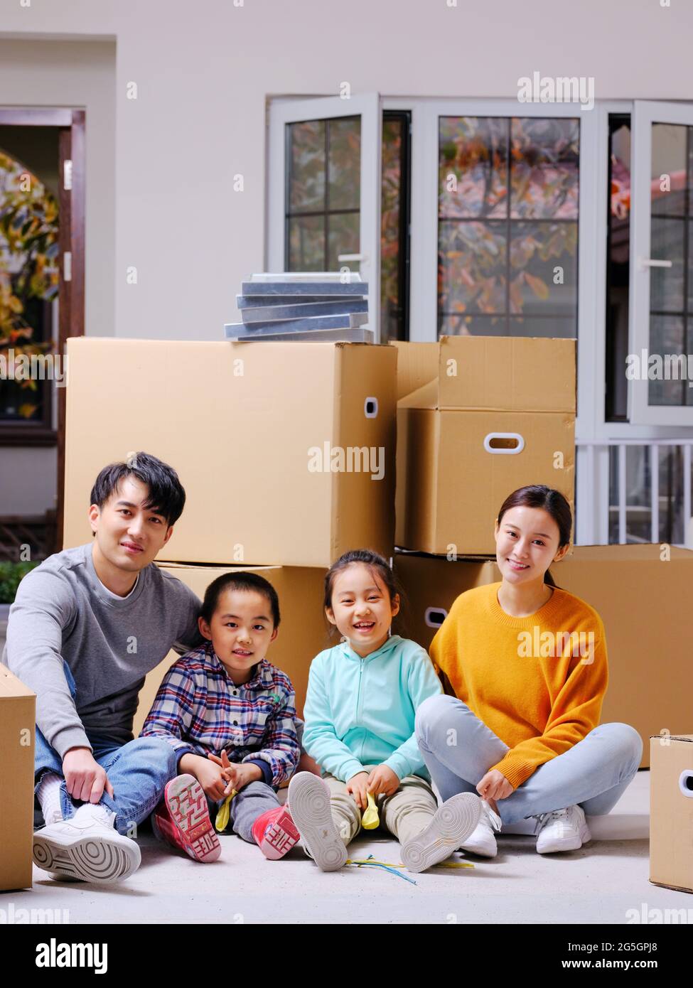 The happy family of four sat on the ground to rest high quality photo Stock Photo