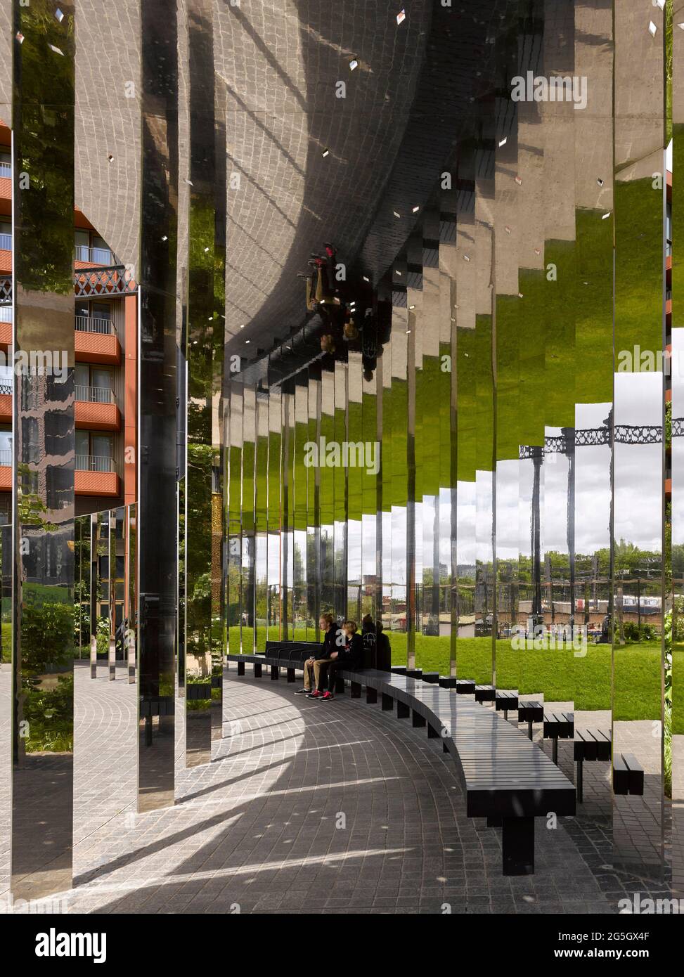 View through mirrored walkway structure. Gasholder Park, London, United