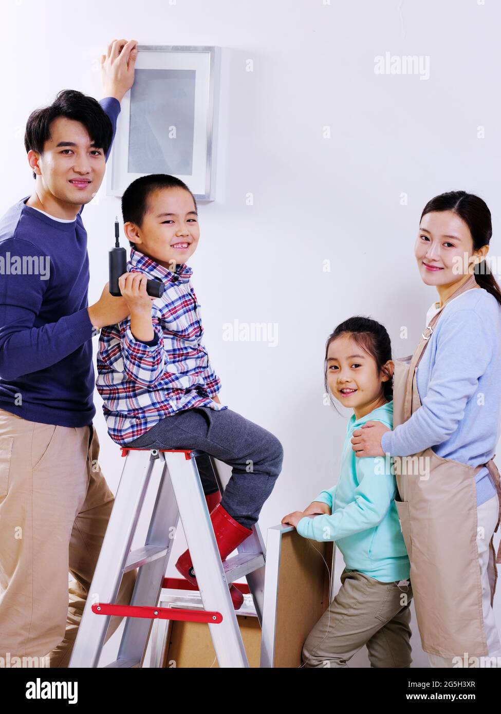 A happy family of four decorates their house high quality photo Stock Photo