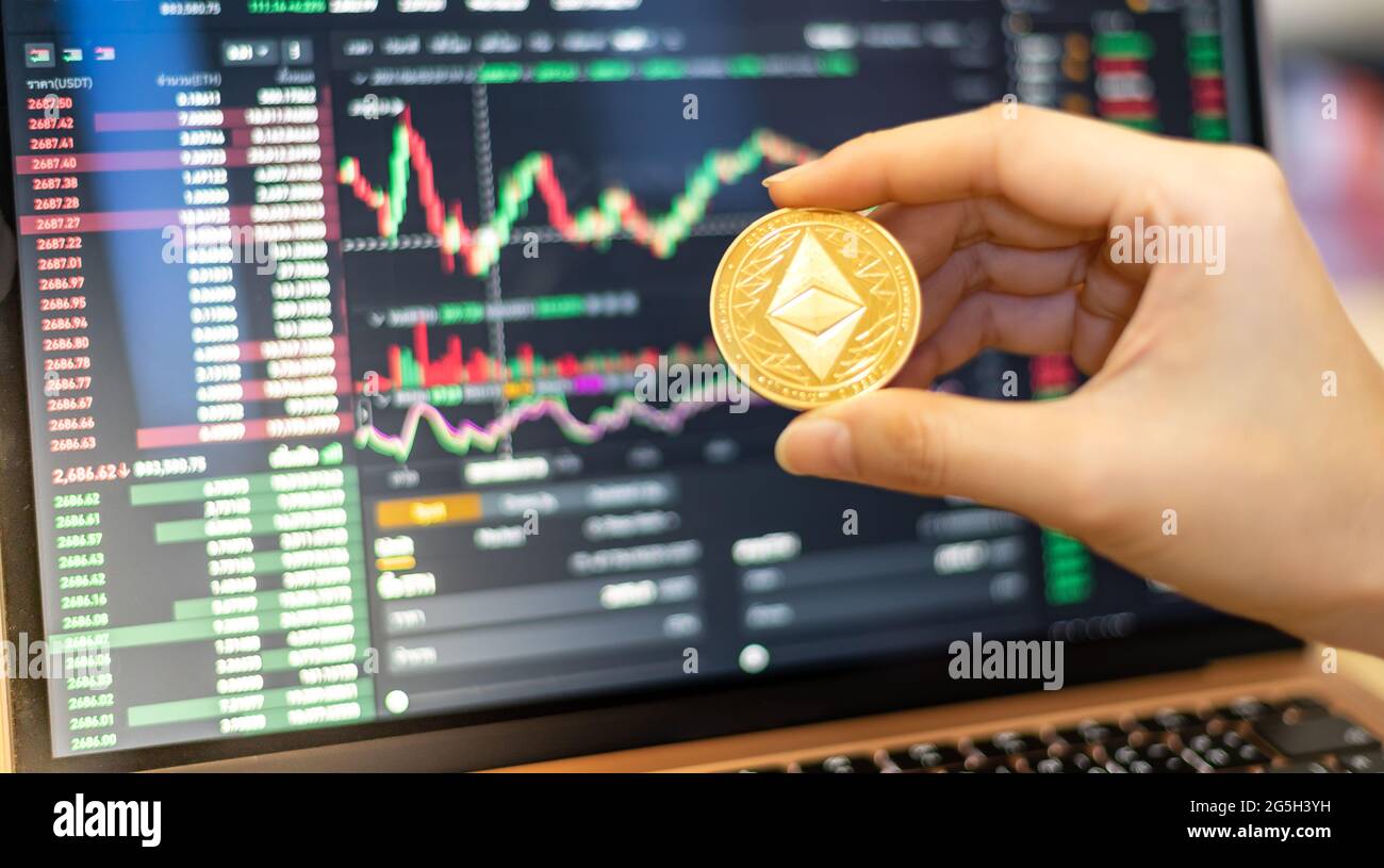One Golden Ethereum coin one of the Cryptocurrency on hand business woman  with the cryptocurrency graph for trading Stock Photo - Alamy