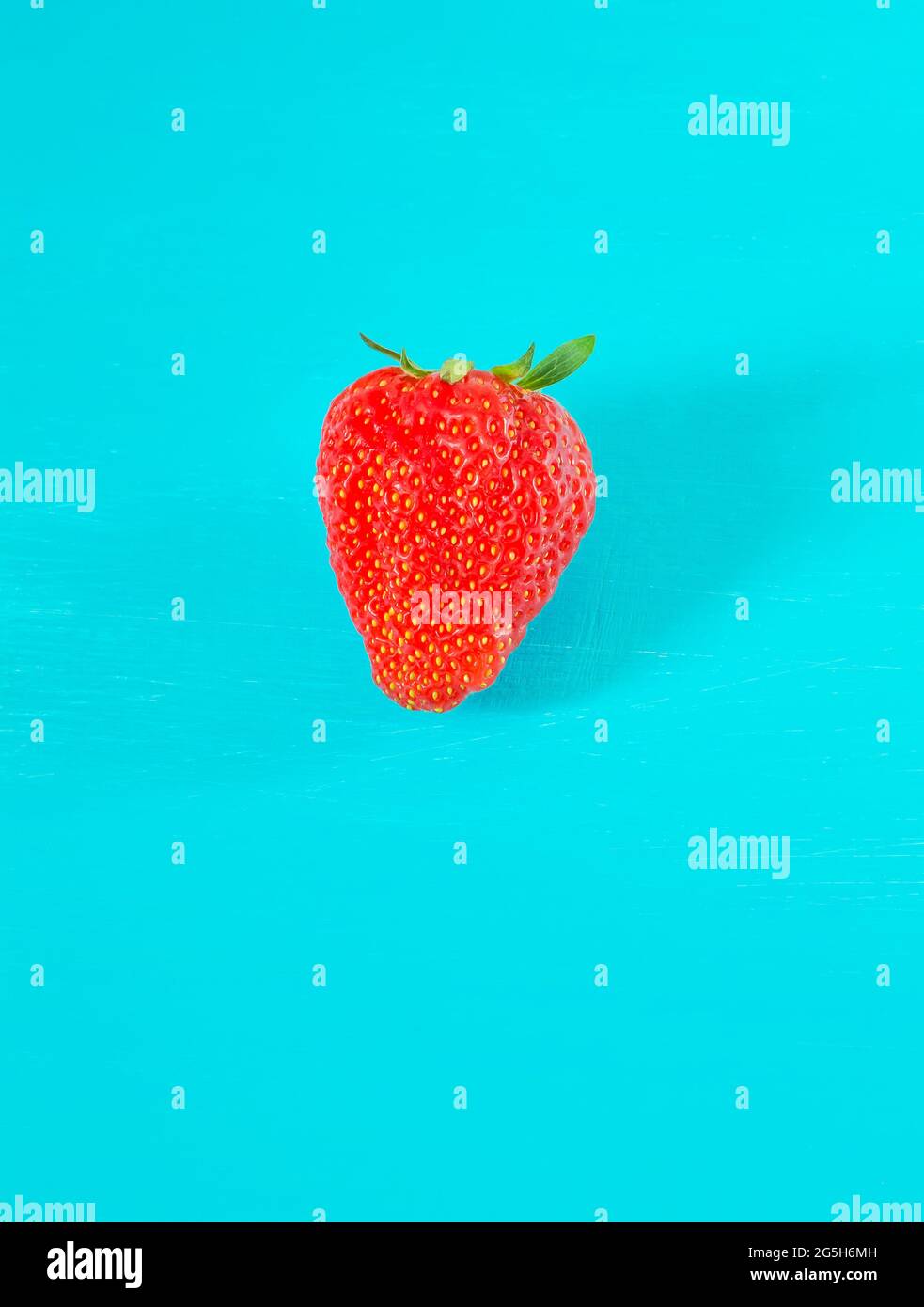 Turquoise Berry One strawberry berry on a turquoise background, vertical format Stock ...