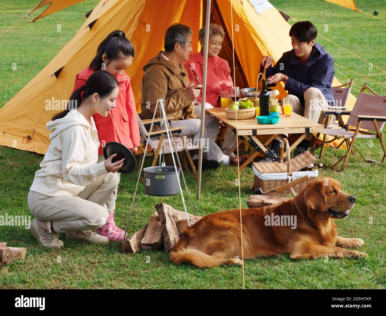 Happy family of five and pet dog have a picnic outdoors high quality photo Stock Photo