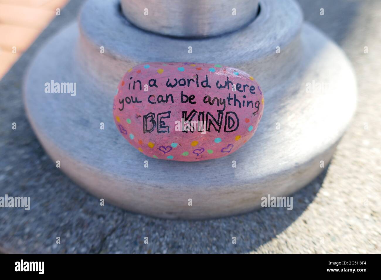 Be kind message painted onto pink kindness rock Stock Photo