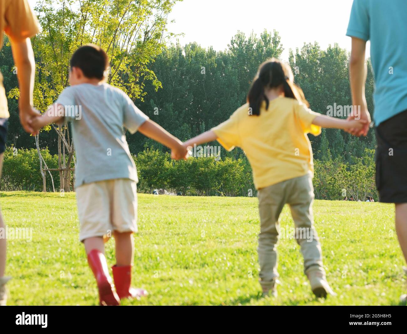 A happy family of four walking in the park high quality photo Stock ...